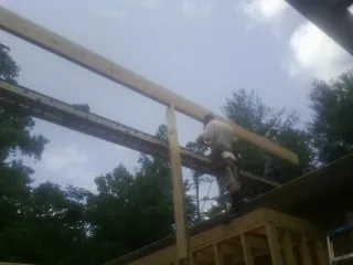 Carpenter setting a ridge beam over a new addition frame — Ice Dam Removal by Roofing Brothers in Covina