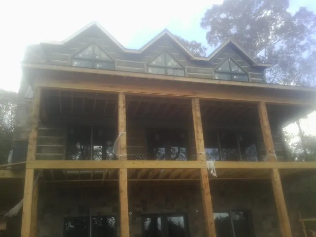 Dormers and porch framing on a large log home under construction — Roof Coating work by our crew in Covina