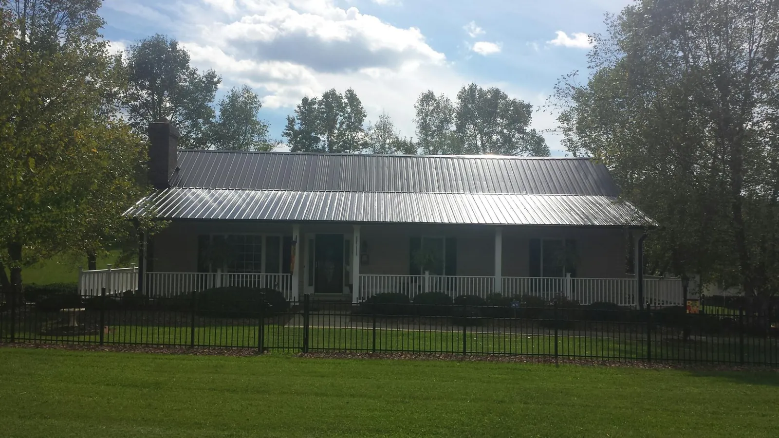 Gray metal roof on a brick ranch with a full width front porch — Gutter Guard Installation work by our crew in Covina